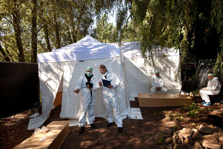 September 2010: werknemers van het NFI staan bij een tent op de begraafplaats St. Barbara. Zij gaan het dna van onbekende lijken vergelijken met materiaal in hun dna-databank. Beeld Guus Dubbelman / de Volkskrant