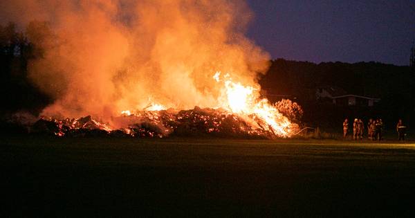 Brandweer laat grote berg snoeiafval in Lathum gecontroleerd afbranden - De Gelderlander