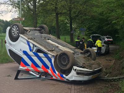Politiewagen over de kop bij achtervolging, automobilist weet te ontkomen