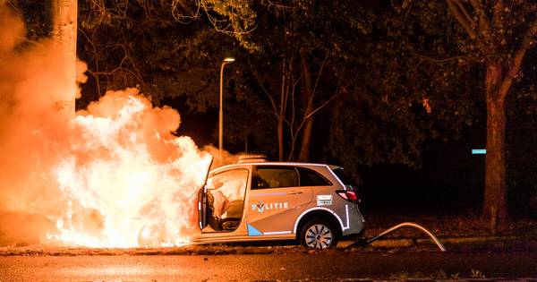 Politieauto vliegt in brand na botsing tegen boom in Tilburg, agente gewond.