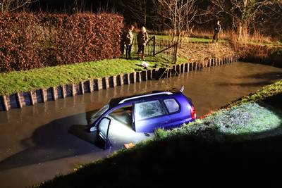 Auto schiet van de weg en belandt in het water langs Van Heemstraweg in Wamel