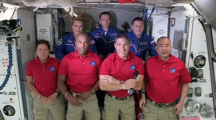 Dragon-crew Shannon Walker, Victor Glover, Mike Hopkins en Soichi Noguchi (vooraan, rode polo's) poserend voor een foto met ISS-crew Kate Rubins, Sergey Ryzhikov en Sergey Kud-Sverchkov.