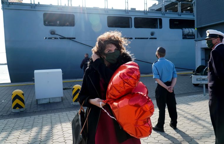 Een vrouw wacht haar familieleden op die zojuist zijn gearriveerd met een schip van de Duitse Marine in Wilhemshaven, op 17 september 2020.  Beeld AFP