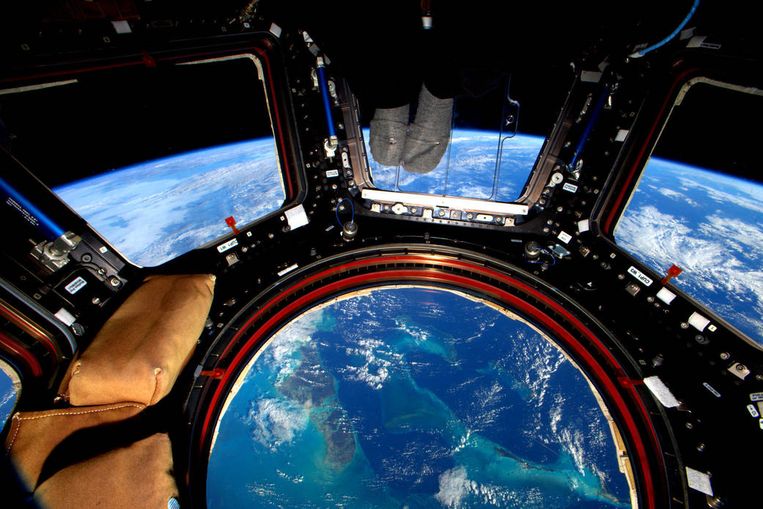 Het ISS, de voeten van Scott Kelly en een uitzicht over de Bahama's.