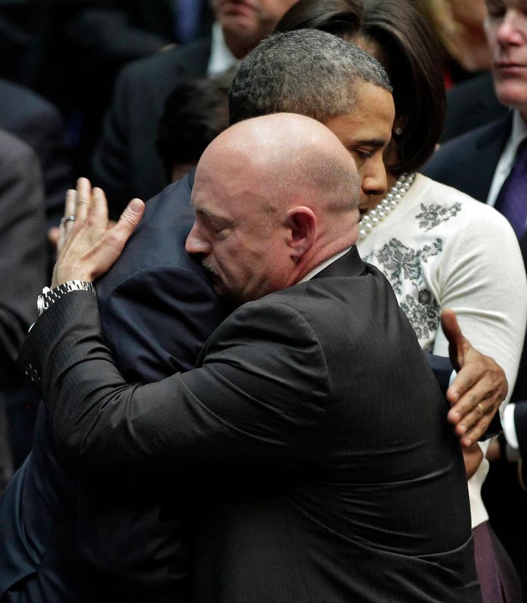 Voormalig Amerikaans president Barack Obama omhelst Mark Scott, tweelingsbroer van Scott en man van Senator Gabrielle Giffords die neergeschoten werd.