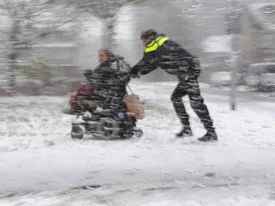 Dienstbaarheid in de sneeuw: wijkagent duwt gestrande scootmobieler naar huis