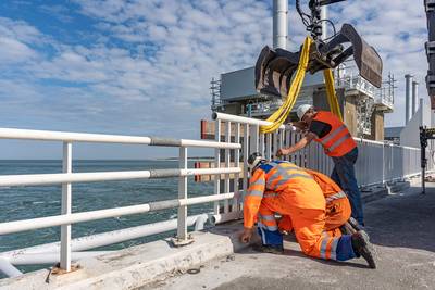 Rijkswaterstaat test nieuwe reling op Oosterscheldekering