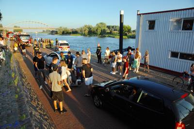 Auto rijdt vanaf Arnhemse Rijnkade de rivier in