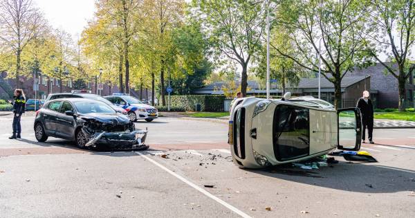 Auto op zn kant na botsing in Tilburg: bestuurders nagekeken door ambulancemedewerkers.