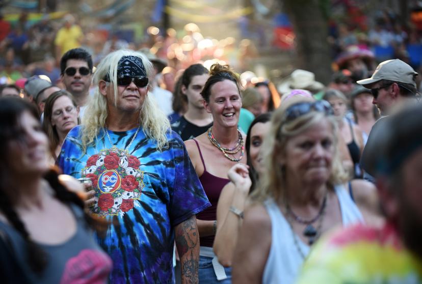 Hippie man met tie-dye shirt en bandana op festival