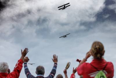 Vliegend Museum Seppe groet de wandelaars van de Stichting Eerste Gemotoriseerde Vlucht in Nederland
