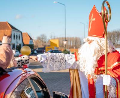 Kinderen in de coronavrije snoepstraat langs Sinterklaas